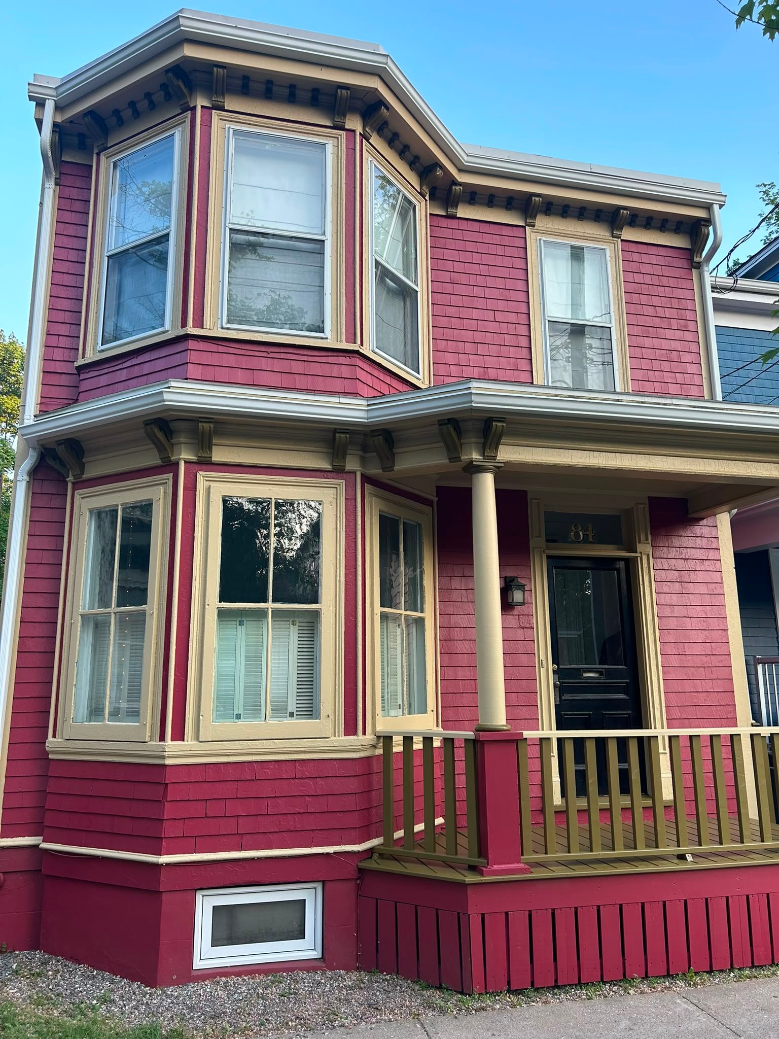 Raspberry shingle exterior with cream trim and olive accents